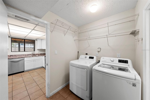 laundry room with washer and clothes dryer, light tile patterned floors, and sink