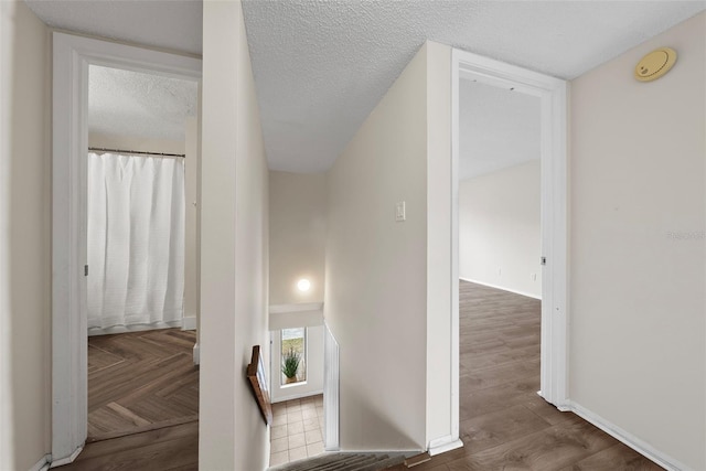 hallway featuring hardwood / wood-style floors and a textured ceiling