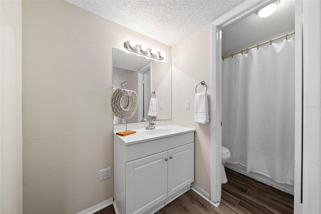 bathroom featuring a shower with shower curtain, vanity, a textured ceiling, hardwood / wood-style floors, and toilet