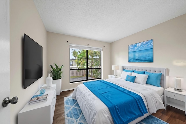 bedroom with a textured ceiling and dark hardwood / wood-style flooring