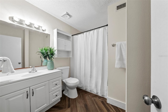 full bathroom featuring parquet flooring, a textured ceiling, toilet, shower / tub combo with curtain, and vanity