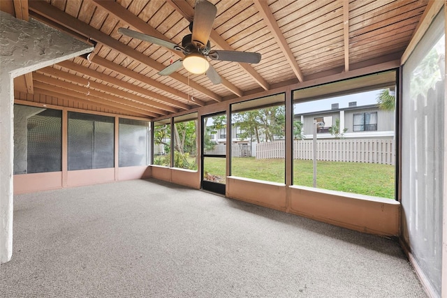 unfurnished sunroom with ceiling fan, beamed ceiling, and wood ceiling