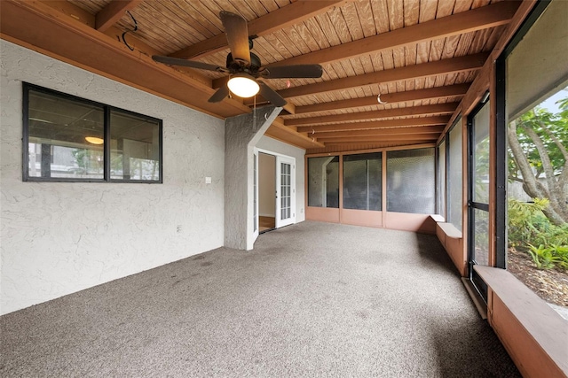 unfurnished sunroom with beam ceiling and ceiling fan