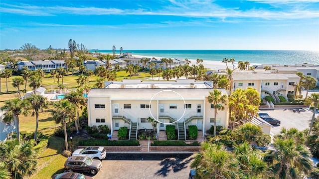 birds eye view of property featuring a beach view and a water view