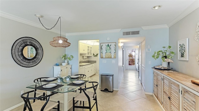 dining space featuring crown molding, sink, and light tile patterned floors