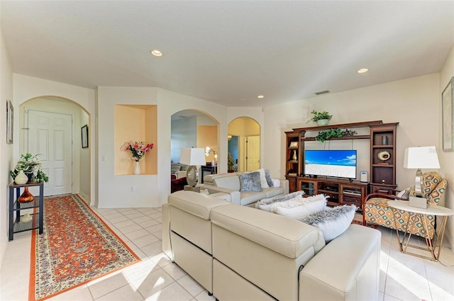 living room featuring recessed lighting, visible vents, arched walkways, and light tile patterned flooring