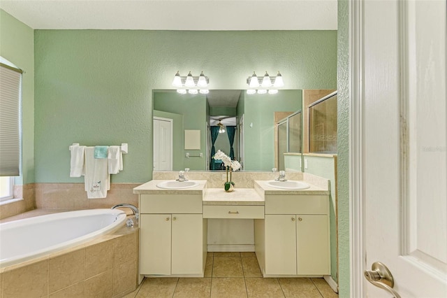 bathroom featuring a stall shower, tile patterned flooring, a bath, and vanity