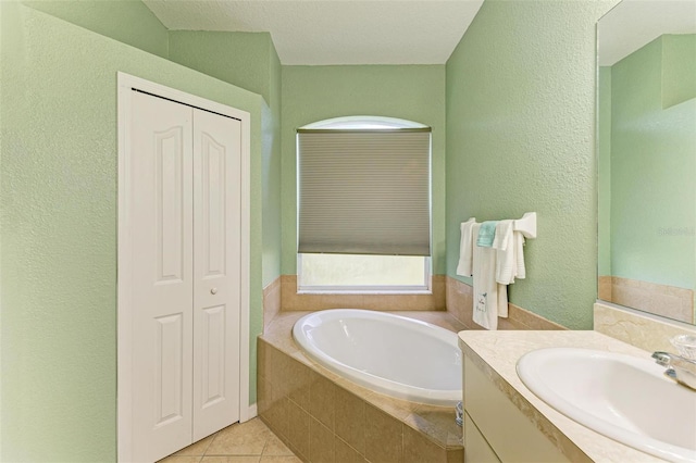 bathroom featuring a garden tub, tile patterned flooring, a closet, and vanity