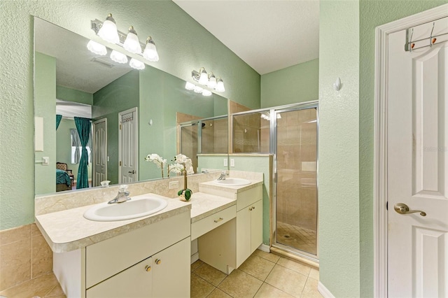 full bathroom with a stall shower, a sink, and tile patterned floors