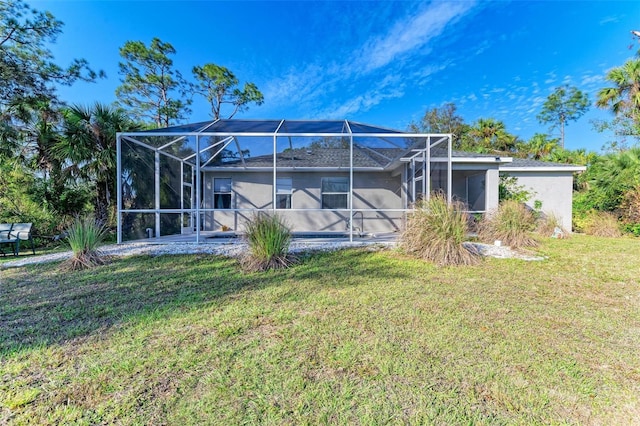 rear view of house with glass enclosure and a lawn