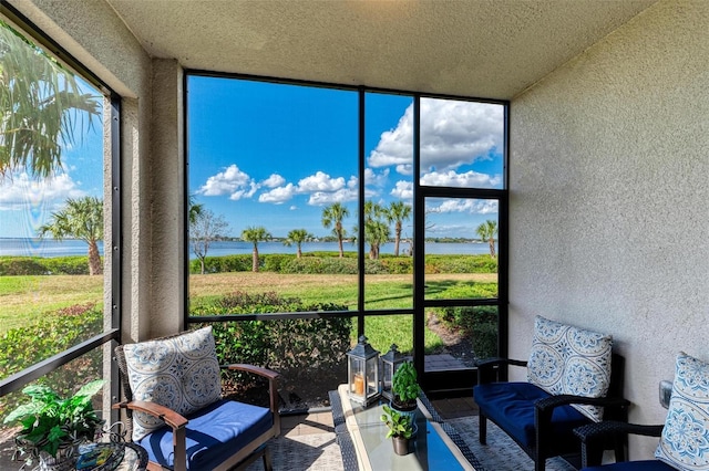 sunroom featuring a water view