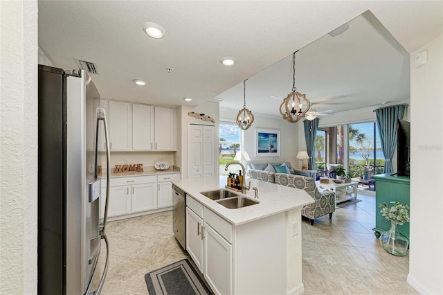 kitchen featuring a center island with sink, white cabinets, sink, appliances with stainless steel finishes, and plenty of natural light