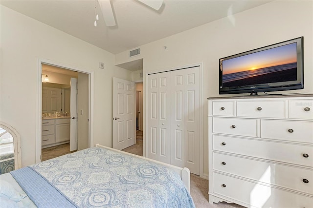 carpeted bedroom with connected bathroom, a closet, and ceiling fan