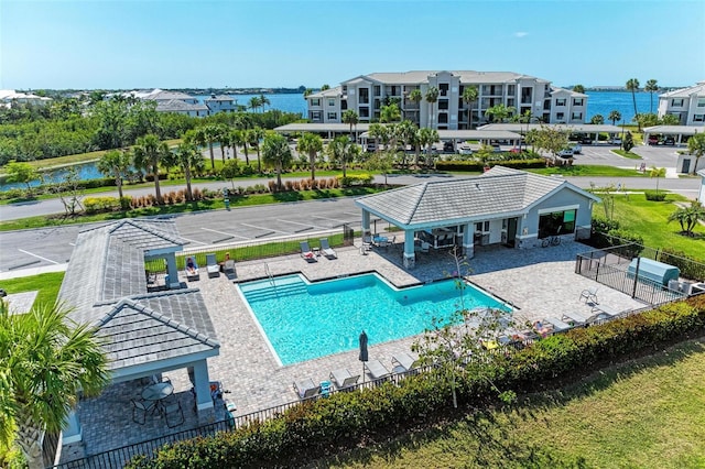 view of swimming pool with a water view and a patio