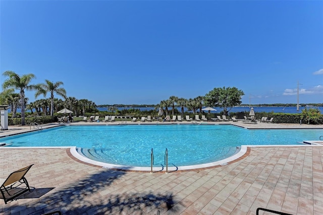 view of pool with a patio and a water view