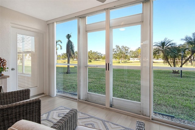 doorway to outside with floor to ceiling windows and light hardwood / wood-style floors