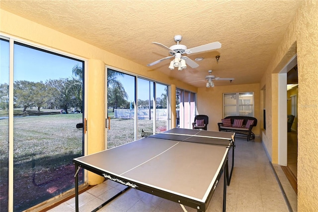 recreation room featuring ceiling fan and a textured ceiling