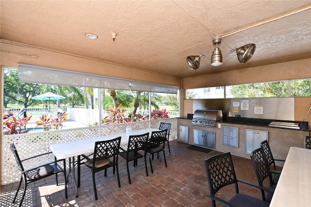 view of patio featuring an outdoor kitchen and a grill