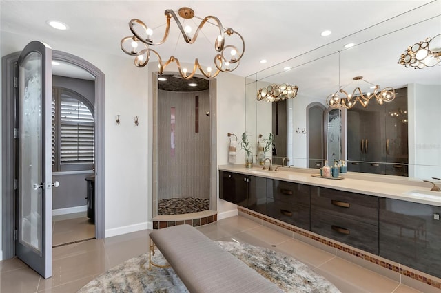 bathroom featuring tile patterned floors, vanity, and a tile shower