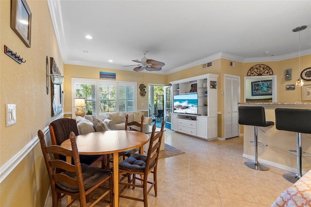 tiled dining area featuring ceiling fan and ornamental molding