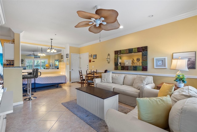 tiled living room with ceiling fan with notable chandelier and crown molding