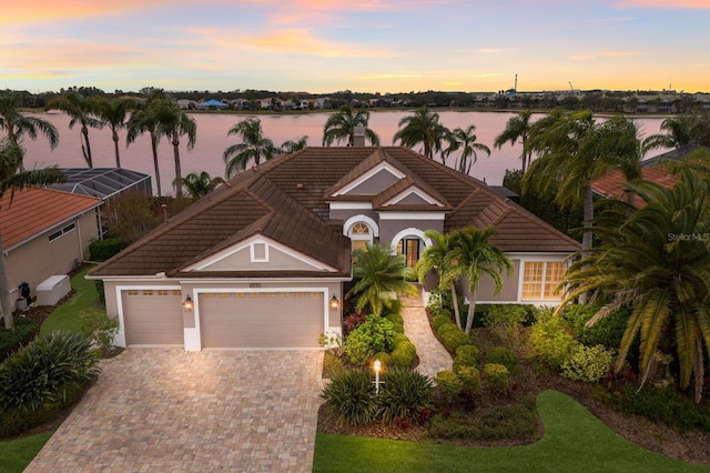 view of front of property with a garage and a water view