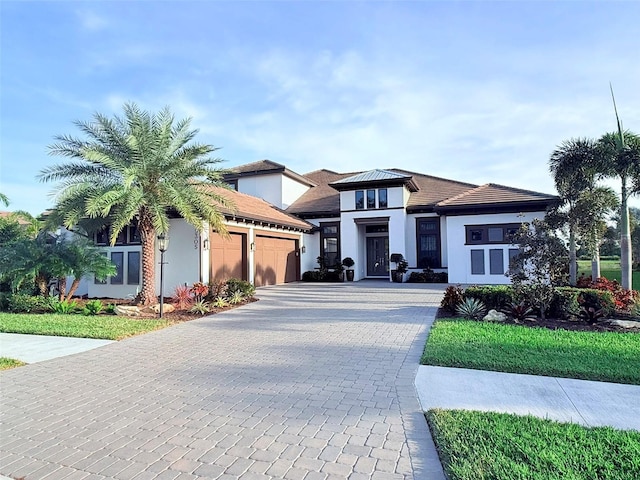 5305 Brookgrove Dr, Sarasota, FL 34238 - prairie-style house featuring decorative driveway, an attached garage, and stucco siding
