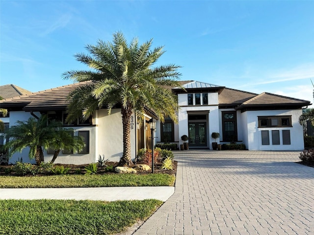 5305 Brookgrove Dr, Sarasota, FL 34238 - prairie-style home featuring a tile roof, decorative driveway, french doors, and stucco siding