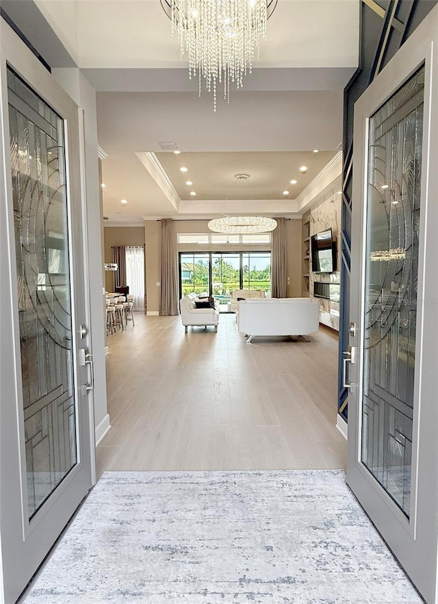 5305 Brookgrove Dr, Sarasota, FL 34238 - foyer entrance with wood finished floors, a tray ceiling, recessed lighting, ornamental molding, and a chandelier