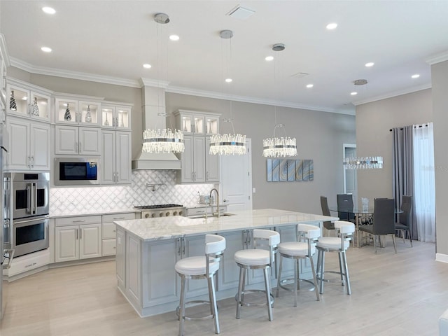 5305 Brookgrove Dr, Sarasota, FL 34238 - kitchen featuring a kitchen island with sink, tasteful backsplash, visible vents, and appliances with stainless steel finishes