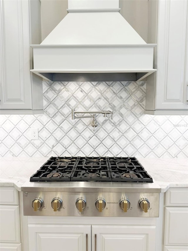 5305 Brookgrove Dr, Sarasota, FL 34238 - kitchen with decorative backsplash, stainless steel gas stovetop, premium range hood, and white cabinets