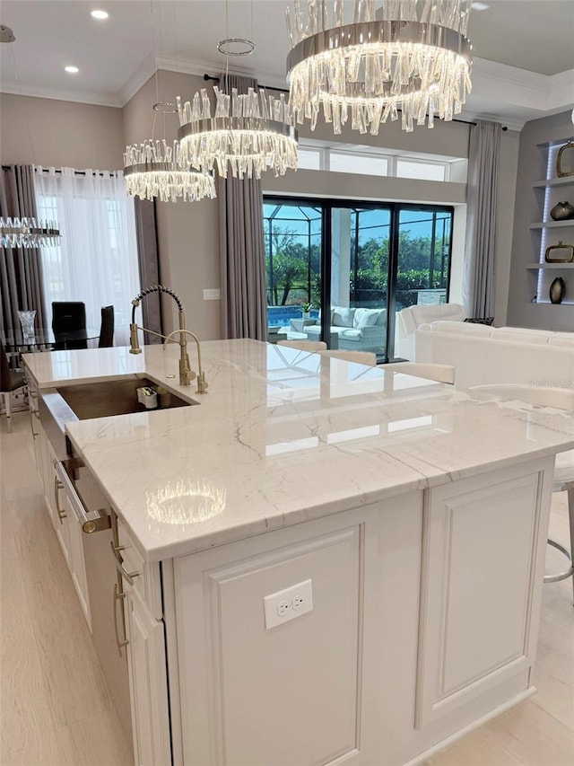 5305 Brookgrove Dr, Sarasota, FL 34238 - kitchen featuring crown molding, open floor plan, a notable chandelier, and a center island with sink