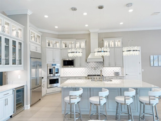 5305 Brookgrove Dr, Sarasota, FL 34238 - kitchen featuring beverage cooler, built in appliances, white cabinetry, and premium range hood