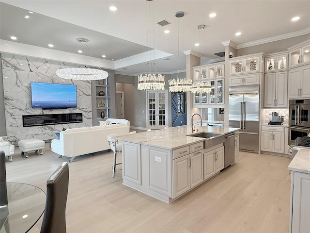 5305 Brookgrove Dr, Sarasota, FL 34238 - kitchen with a large island, a sink, open floor plan, stainless steel appliances, and light wood finished floors