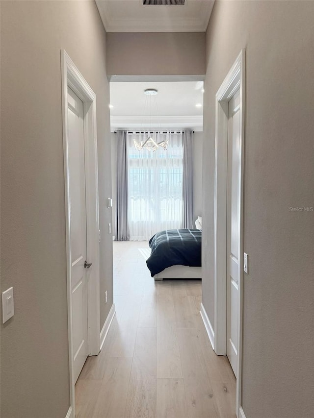 5305 Brookgrove Dr, Sarasota, FL 34238 - corridor featuring baseboards, light wood-type flooring, crown molding, and an inviting chandelier