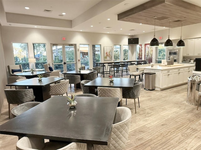 5305 Brookgrove Dr, Sarasota, FL 34238 - dining space with a raised ceiling, recessed lighting, visible vents, and light wood finished floors