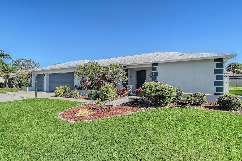 ranch-style house with a garage and a front lawn