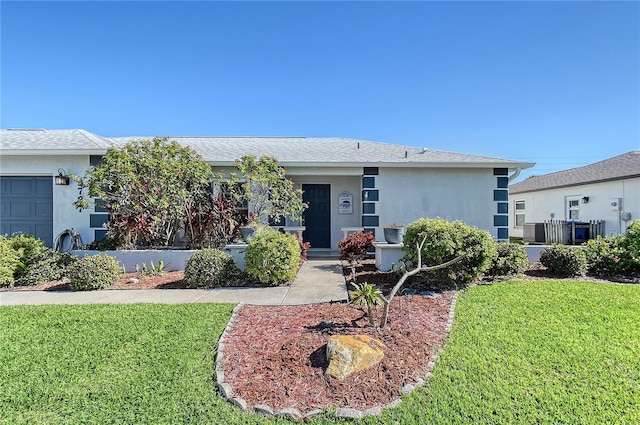 single story home with a garage and a front lawn