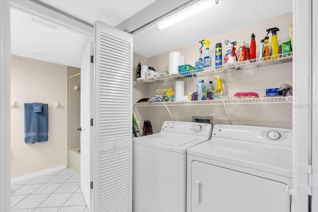 laundry room featuring light tile patterned flooring, washer and dryer, and a textured ceiling