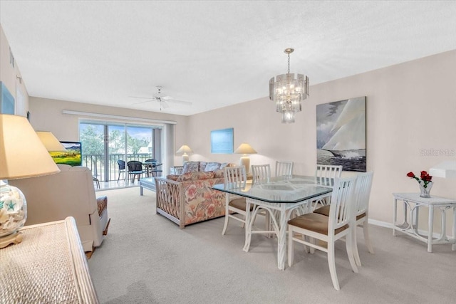 dining space with ceiling fan with notable chandelier and light carpet