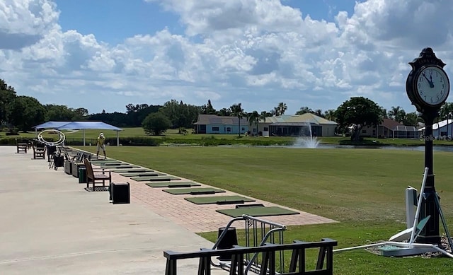 view of property's community with a lawn and a water view