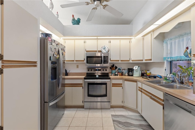 kitchen featuring white cabinetry, light tile patterned flooring, appliances with stainless steel finishes, and sink