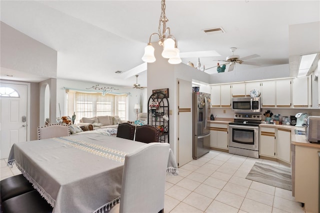 interior space with ceiling fan, lofted ceiling, appliances with stainless steel finishes, and hanging light fixtures