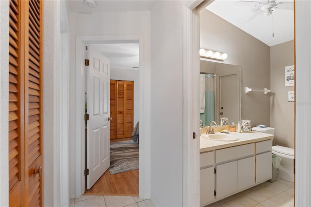 bathroom with ceiling fan, vanity, toilet, and tile patterned flooring