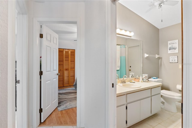 bathroom with tile patterned flooring, vanity, ceiling fan, and toilet