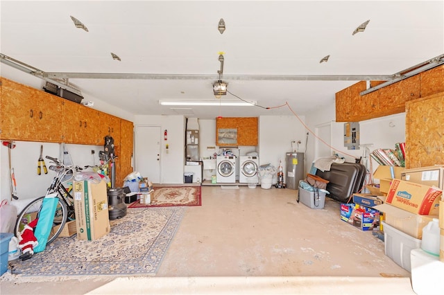 garage with a garage door opener, washing machine and dryer, electric water heater, and electric panel