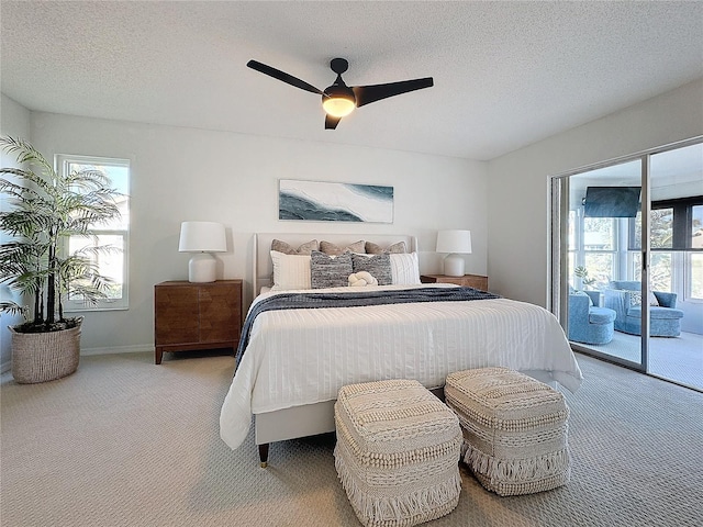 bedroom featuring access to exterior, ceiling fan, light colored carpet, and a textured ceiling