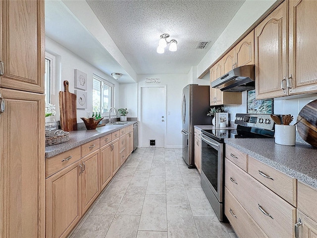 kitchen with sink, decorative backsplash, light tile patterned floors, a textured ceiling, and appliances with stainless steel finishes