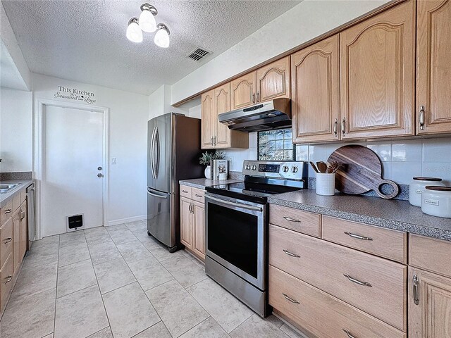 kitchen featuring light tile patterned floors, a textured ceiling, stainless steel appliances, and tasteful backsplash