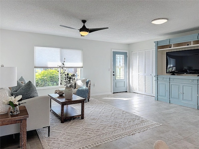 tiled living room with ceiling fan and a textured ceiling